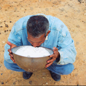 Camel breeder drinks milk in Dakhla, Morocco
